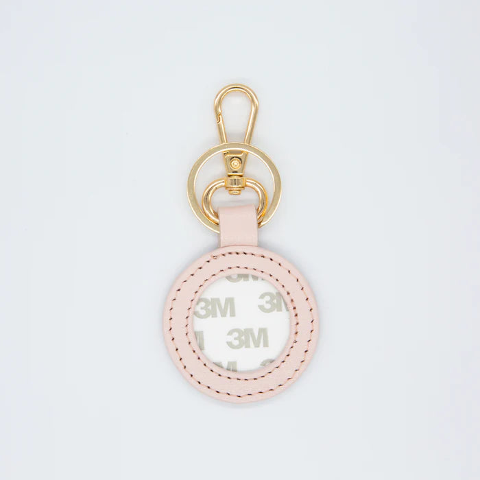 Pink keychain with gold ring on a light gray background