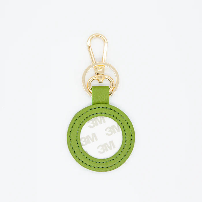 Green keychain with gold ring on a white background