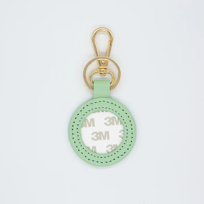 Mint green keychain with gold clasp on a light gray background