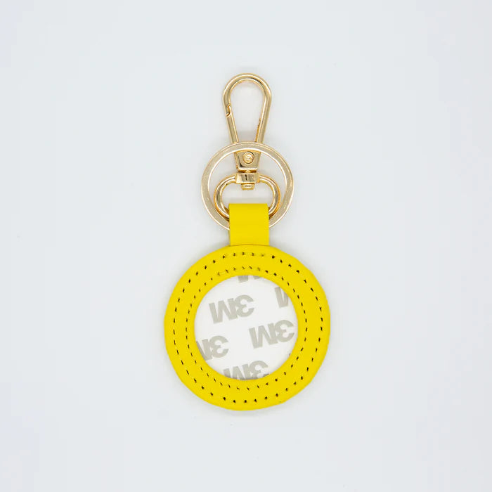 Yellow keychain with gold clasp on a light gray background
